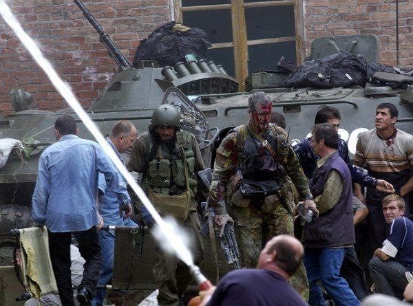 Этого раненого офицера западные журналисты позже прозовут "Русский танк", он несколько раз с ранениями вернётся за детьми в школу. Беслан, 2004 год