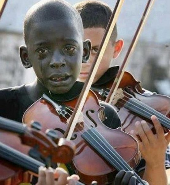 Ребенок играет на скрипке на похоронах своего учителя по музыке. Учитель спас его от нищеты и насилия.